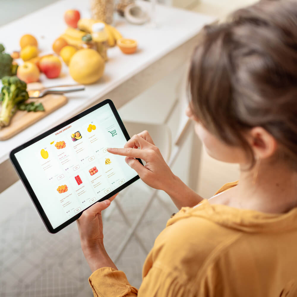 Services - Customer Experience - CXR Outcome visual of a woman purchasing fruit on her iPad.