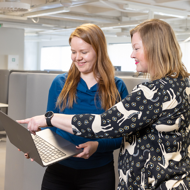 Image of Vaimo employees looking at laptop together.