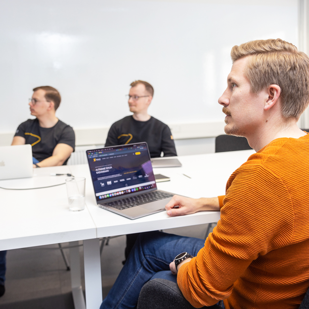 Image of Vaimo employees during a meeting in a conference room. Presumably working.