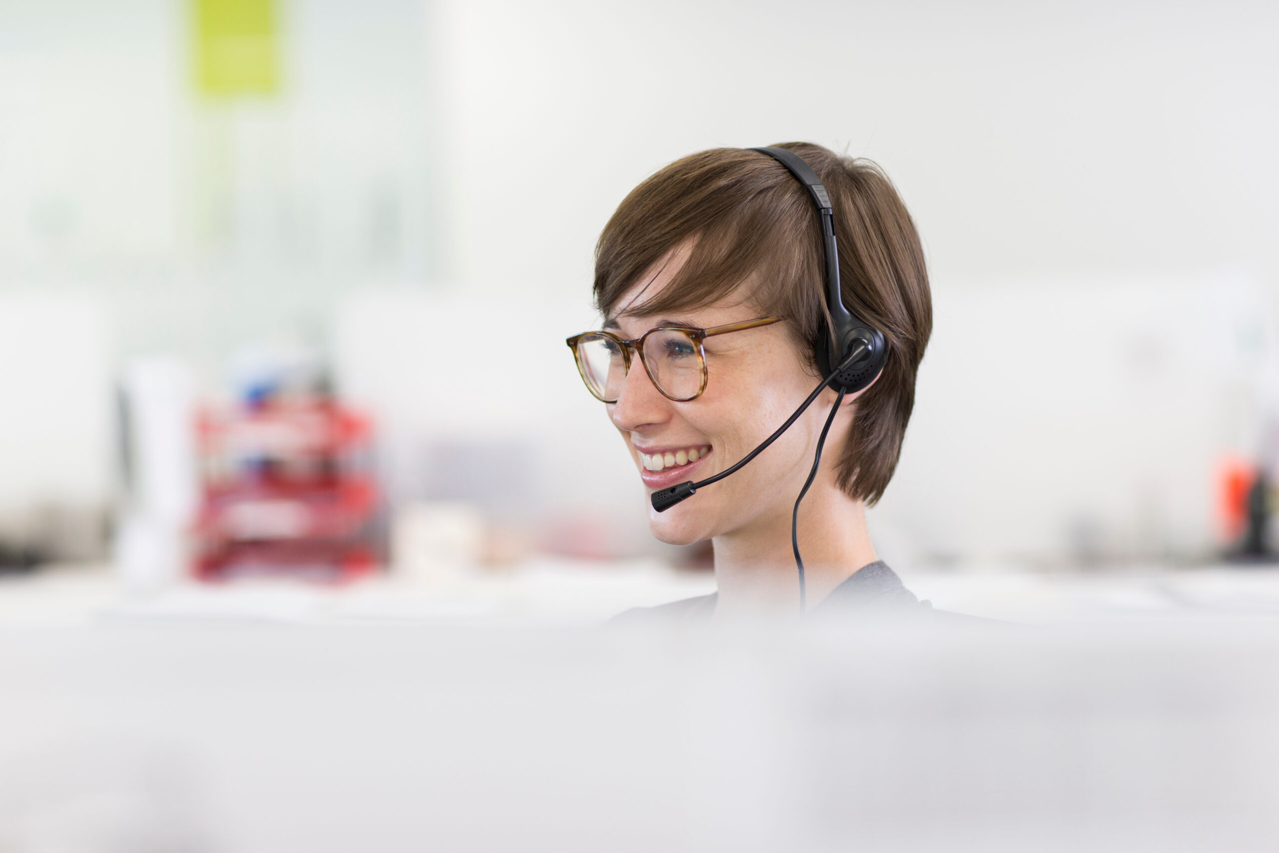 Smiling woman wearing headphones at work.