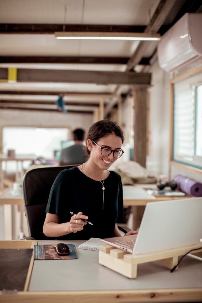 Woman working at desk, smiling and sa