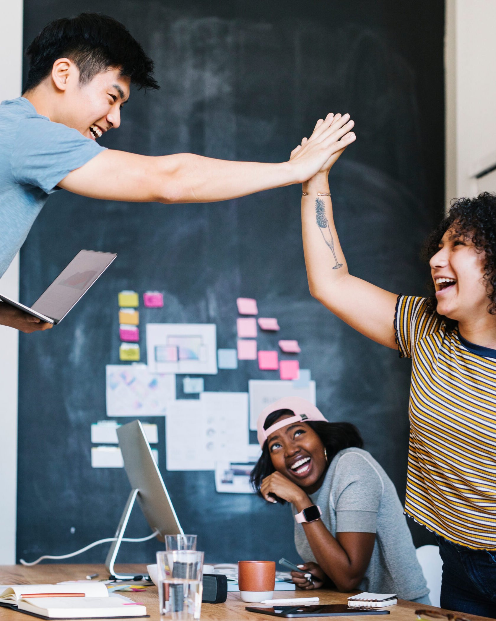 Happy diverse colleagues in a meeting doing a high five