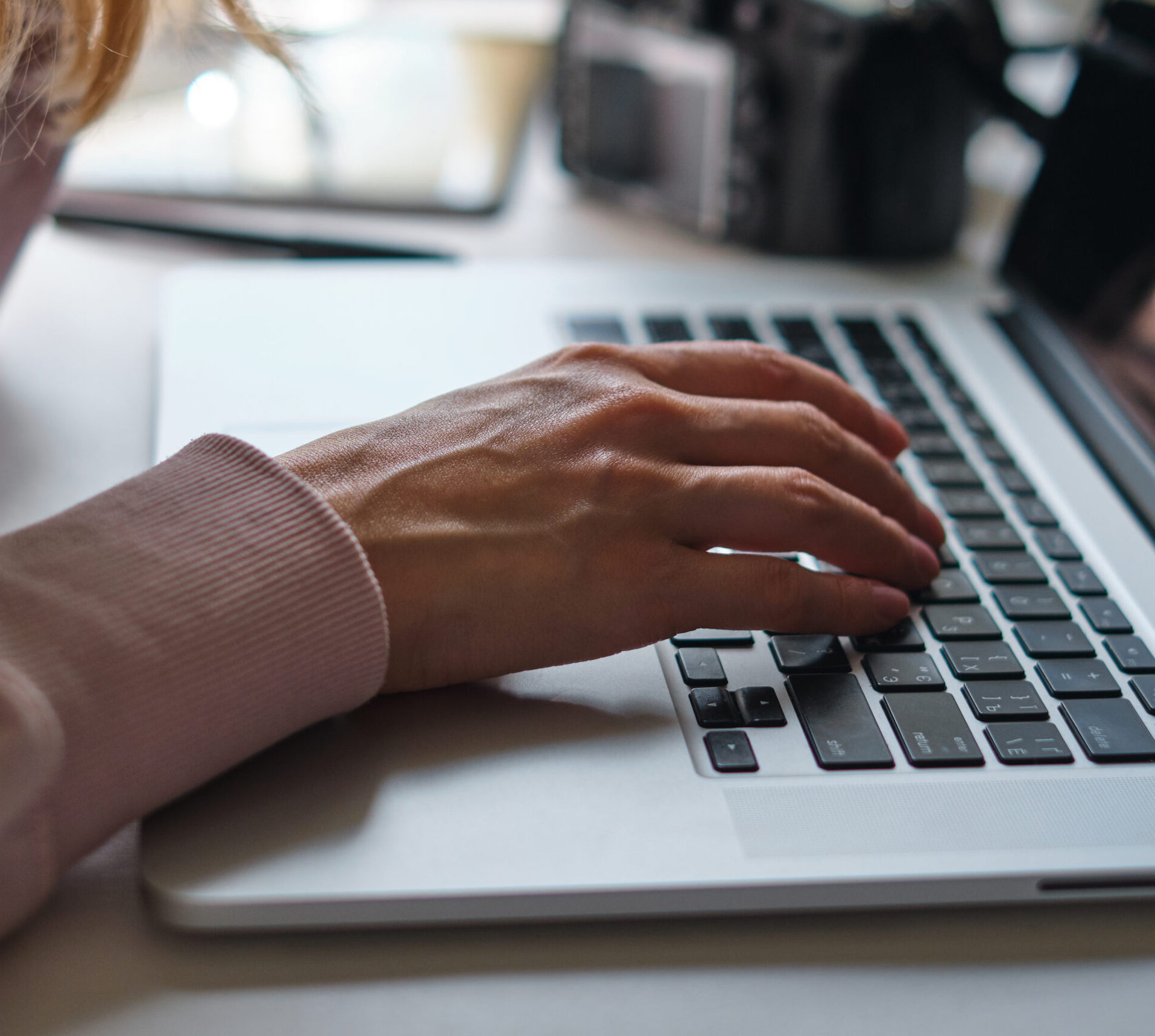 Hand poised over a laptop keyboard