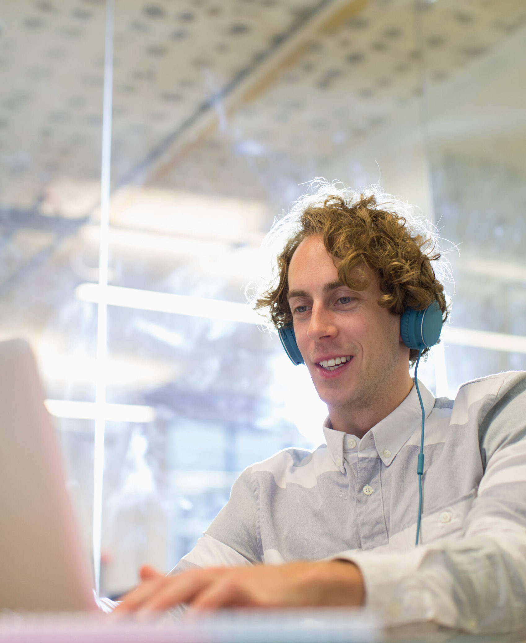 Happy man working with headphones and a laptop