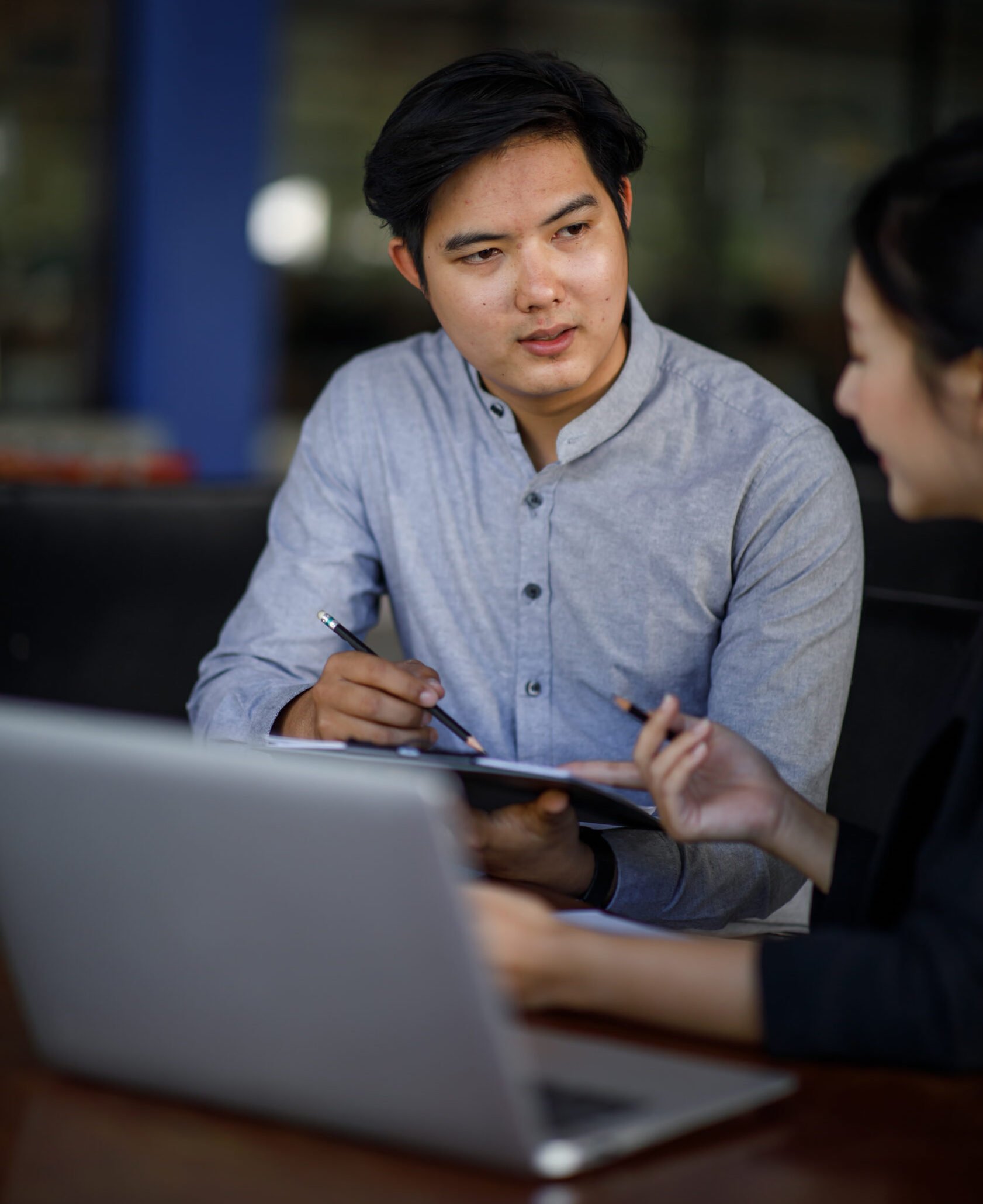 Two men working behind a laptop and discussing business