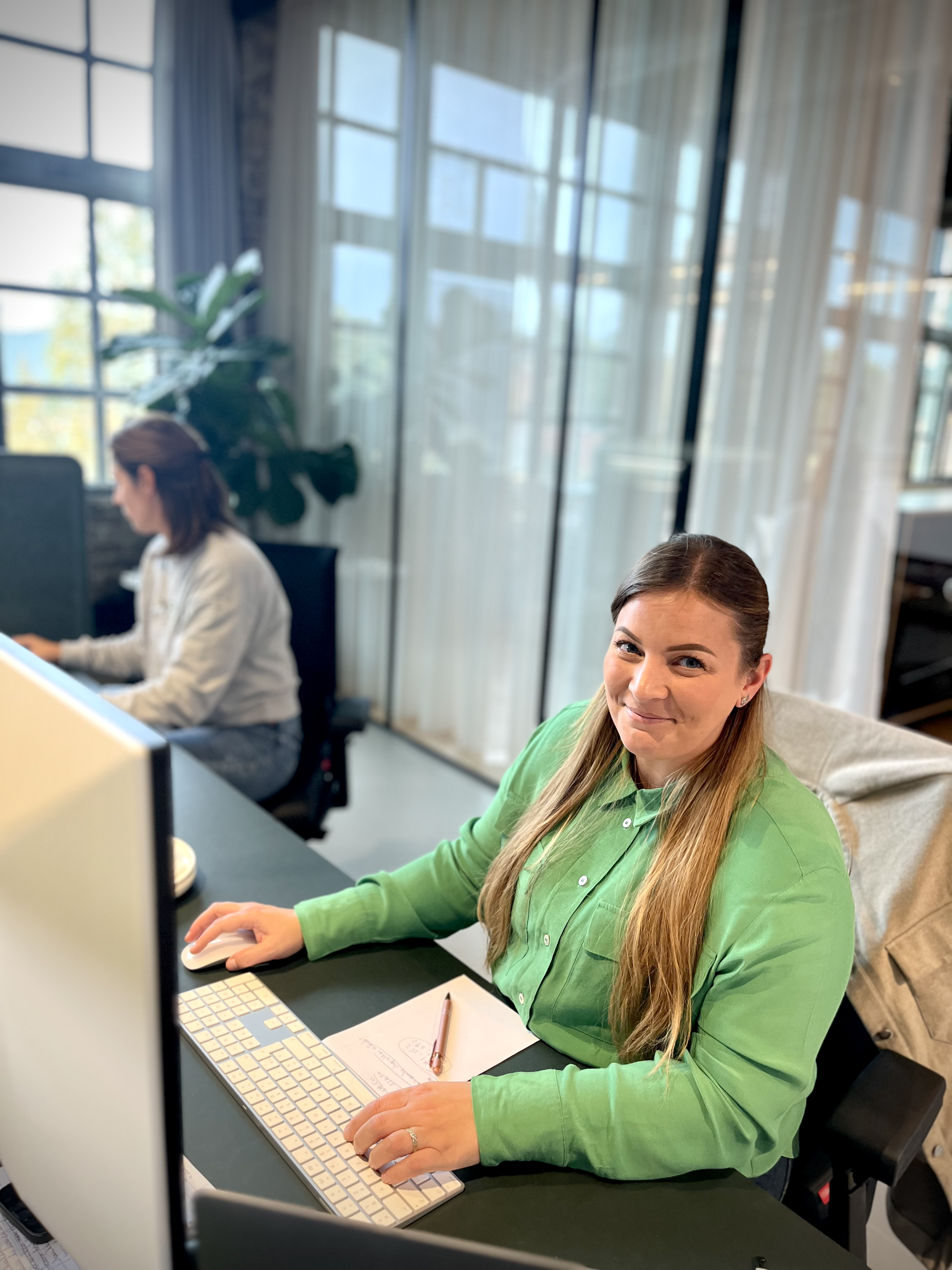 photo of smiling vaimo employee behind her computer