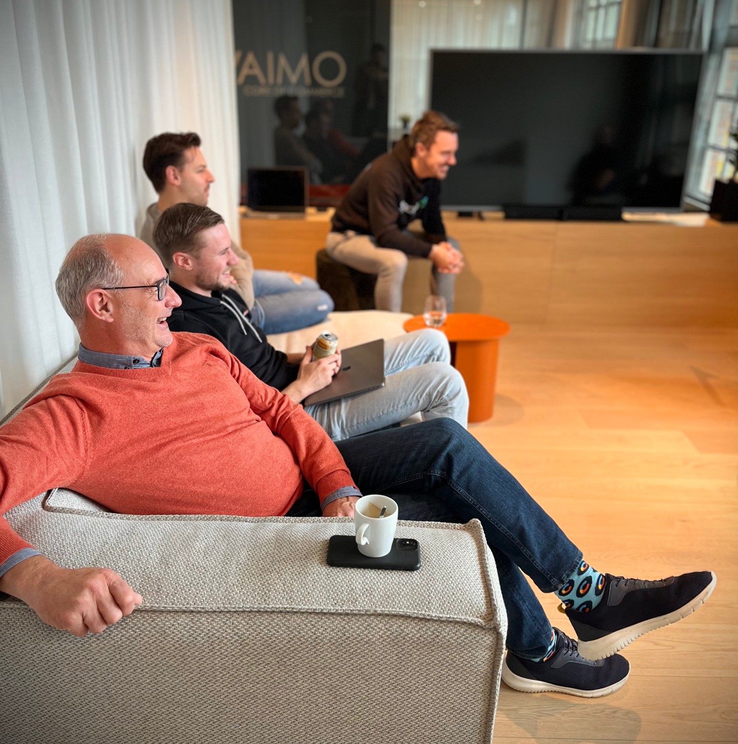 Happy Vaimo employees sitting on a couch