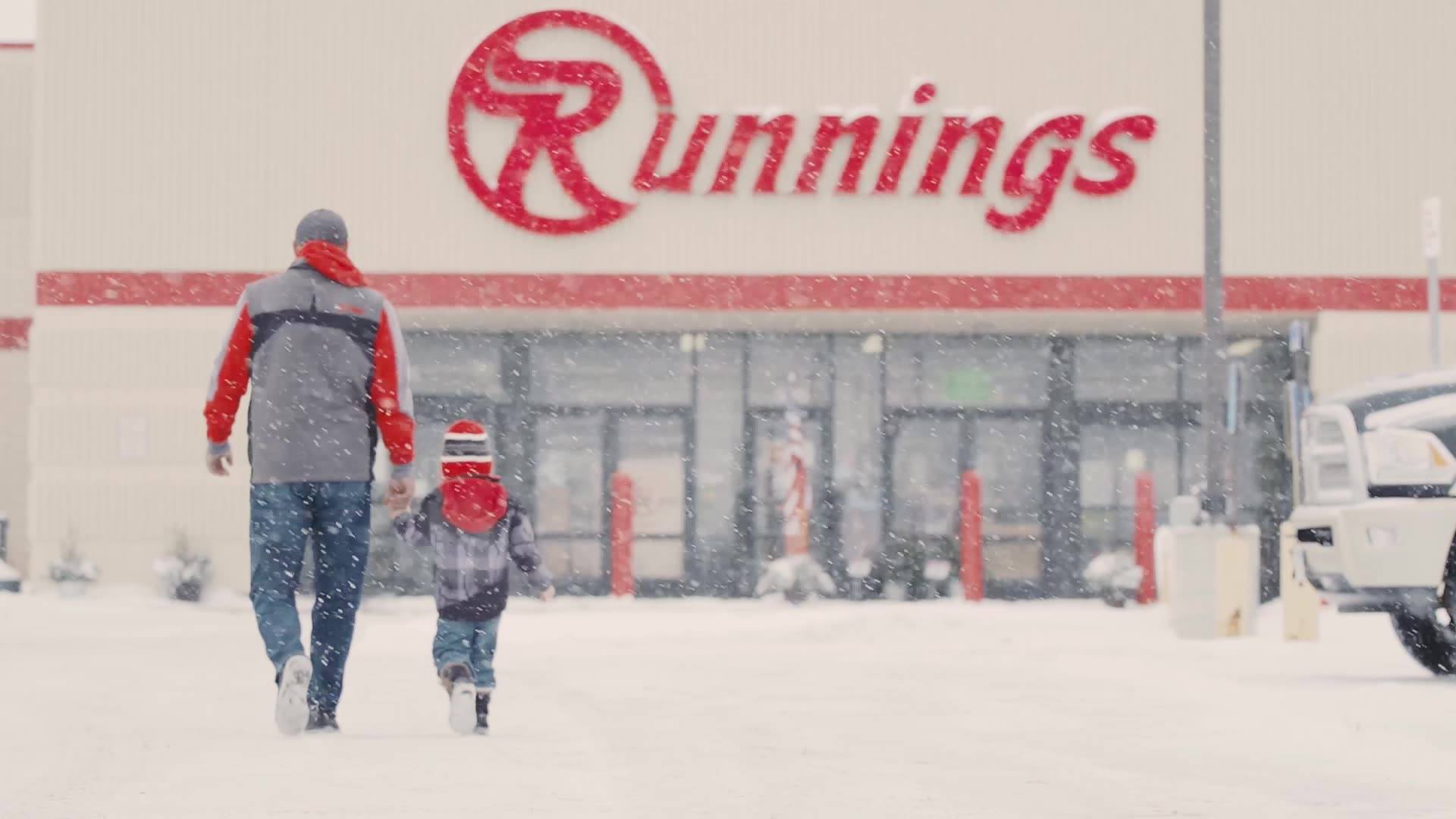 Image of father and son walking to Running store in a snow storm