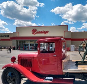 Image of cheery red vintage truck parked in front of Runnings store
