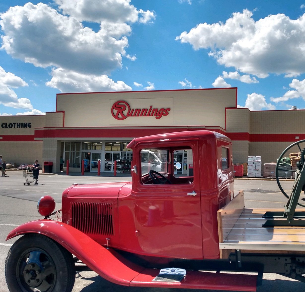 Image of cheery red vintage truck parked in front of Runnings store