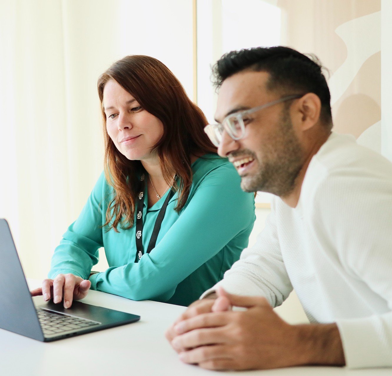 photo of two happy Vaimo employees looking at a laptop