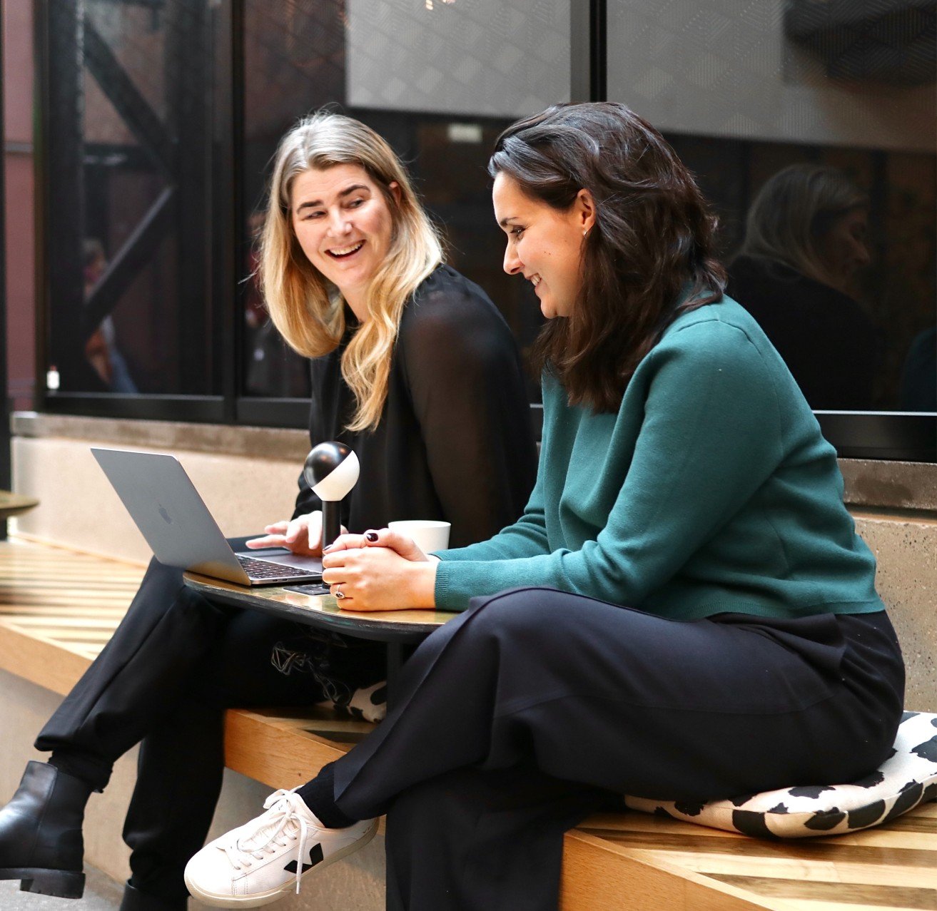 Two happy vaimo employees looking at laptop