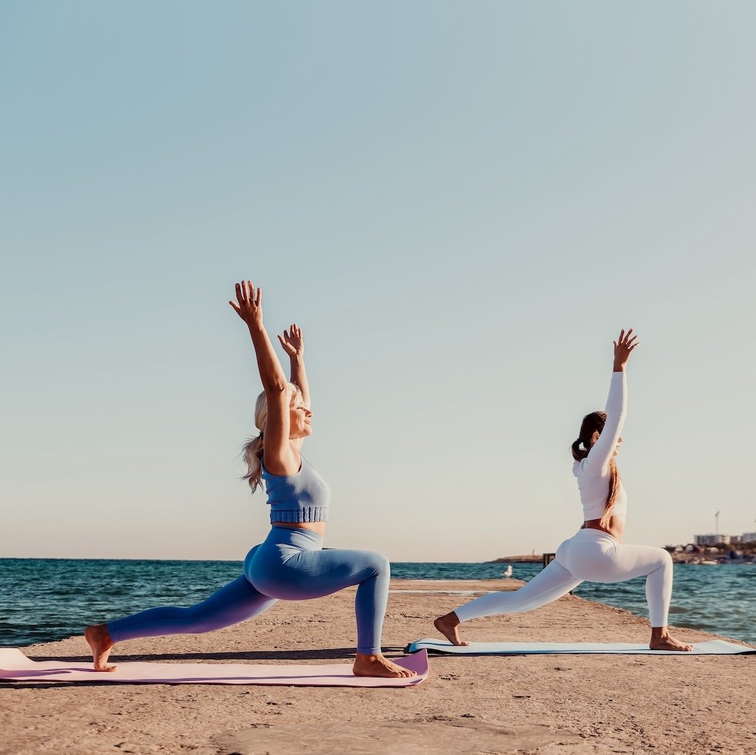 Two women doing yoga outside