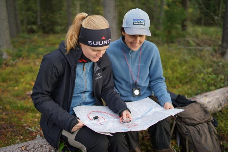 Two friends looking at the map with compass