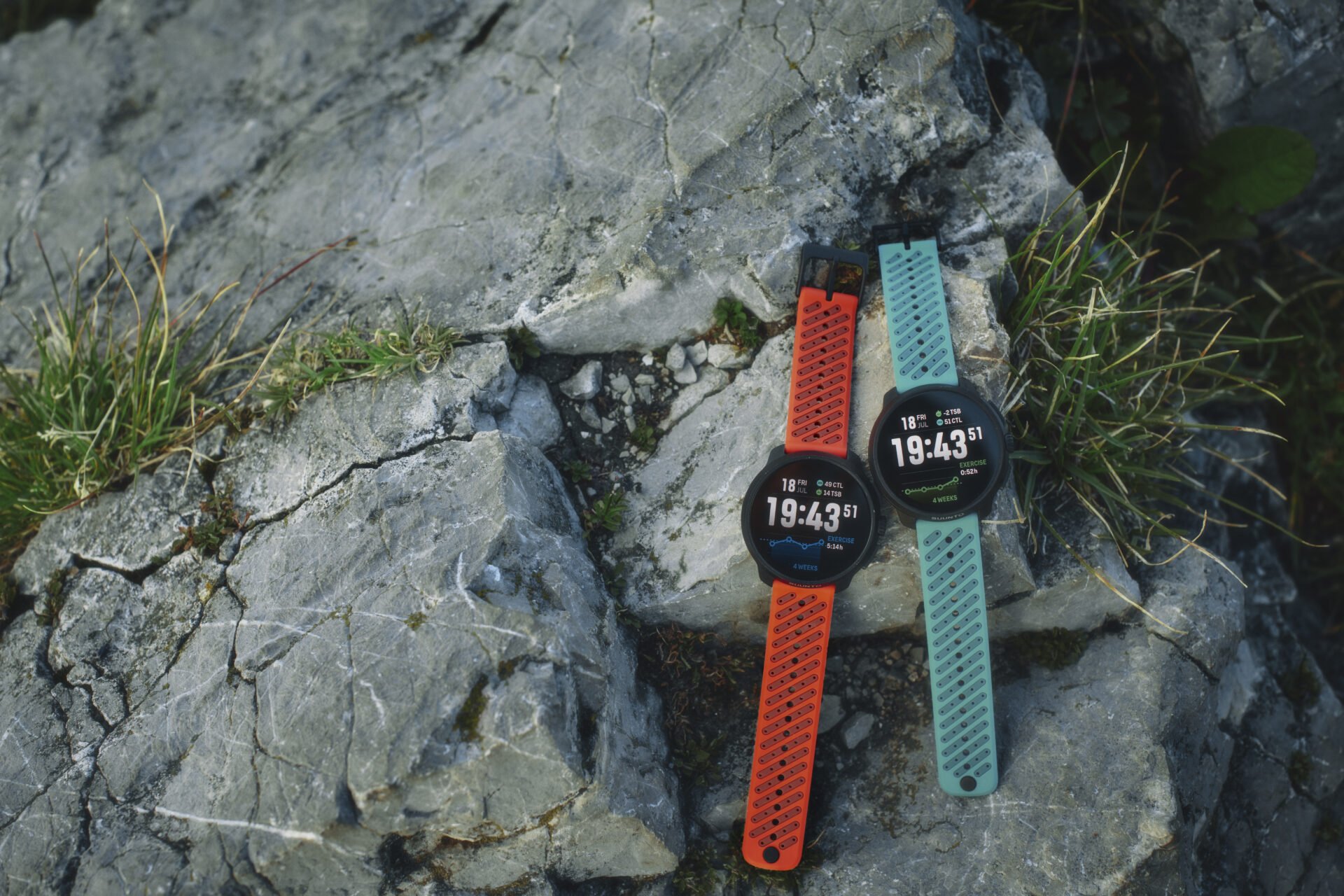 Two Suunto sports watches, on rocks