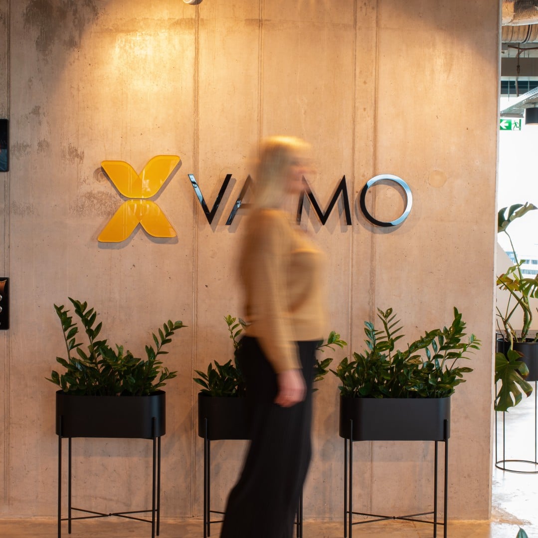 Woman walking in front of Vaimo logo